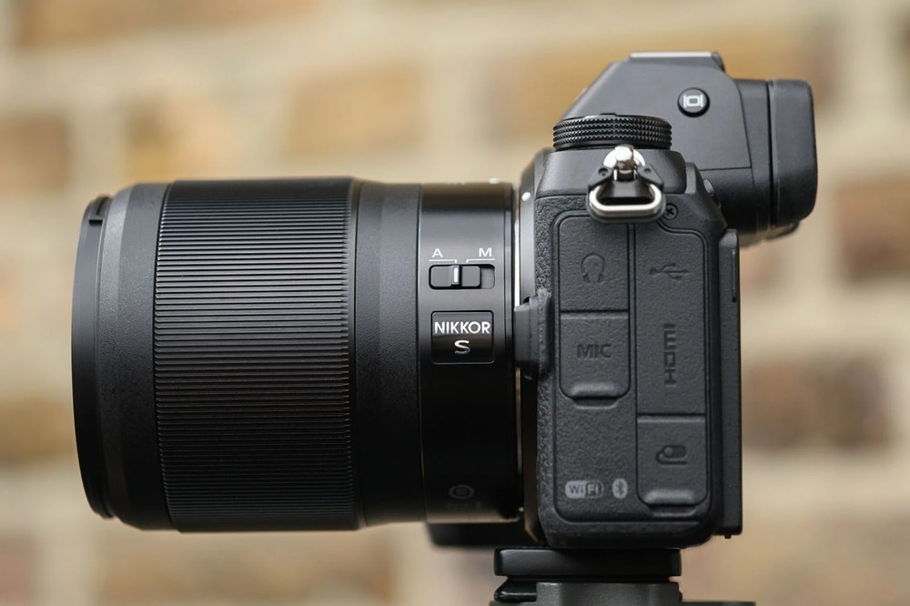 Профіль камери Nikon Z з встановленим об'єктивом Nikkor S-Line, фокус на перемикачі режимів ручного та автоматичного фокусування, видно логотип серії на корпусі.